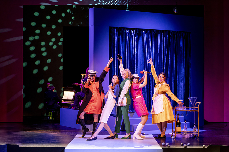 im Hintergrund: Band</br>
im Vordergrund: Julia Sylvester (George Wickham), Nadja Roxana Schimonsky (Effie), Marie-Louise von Gottberg (Flo), Heidi Lehnert (Anne), Annalena Oswald (Tillie).</br>

Foto: Dirk Rückschloß/Pixore Photography