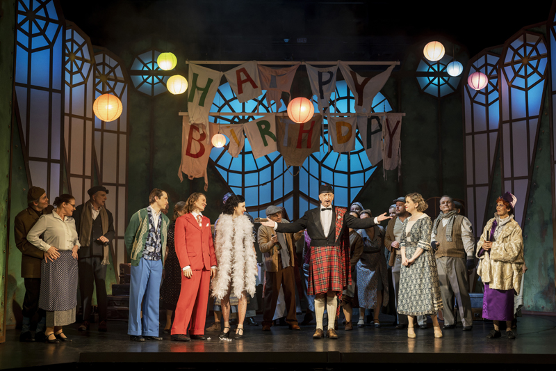 im Hintergrund: Opernchor des Eduard-von-Winterstein-Theaters.<br />im Vordergrund: László Varga (Frederic Chasuble), Bettina Grothkopf (Laetitia Prism), Vincent Wilke (Jack), Richard Glöckner (Algernon), Zsófia Szabó (Cecily), KS Leander de Marel (Der Butler), Magdalena Hallste (Gwendolen) und Gundula Natschinski (Lady Bracknell).<br />Foto: Dirk Rückschloß/Pixore Photography